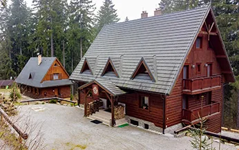 Drevená budova Harmony AP Resort obklopená stromami
